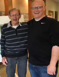 Don and Lance Maddux two men standing side by side smiling at museum