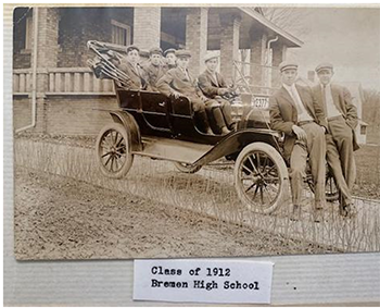 old photo of ford truck, men standing and sitting in vehicle